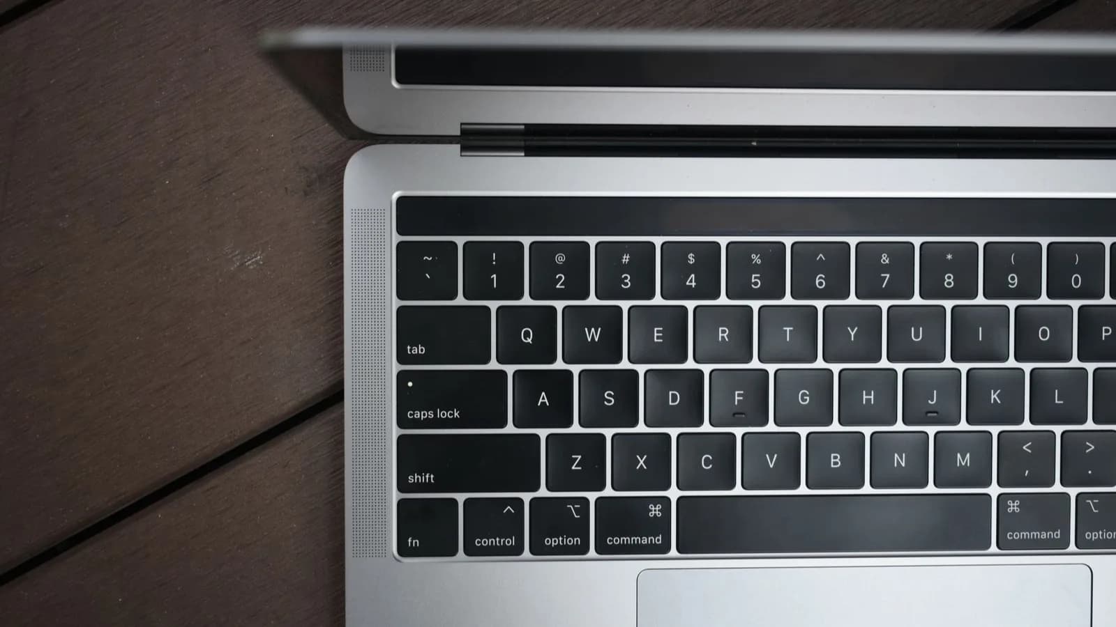 Ordinateur portable MacBook Pro ouvert, posé sur un plancher en bois